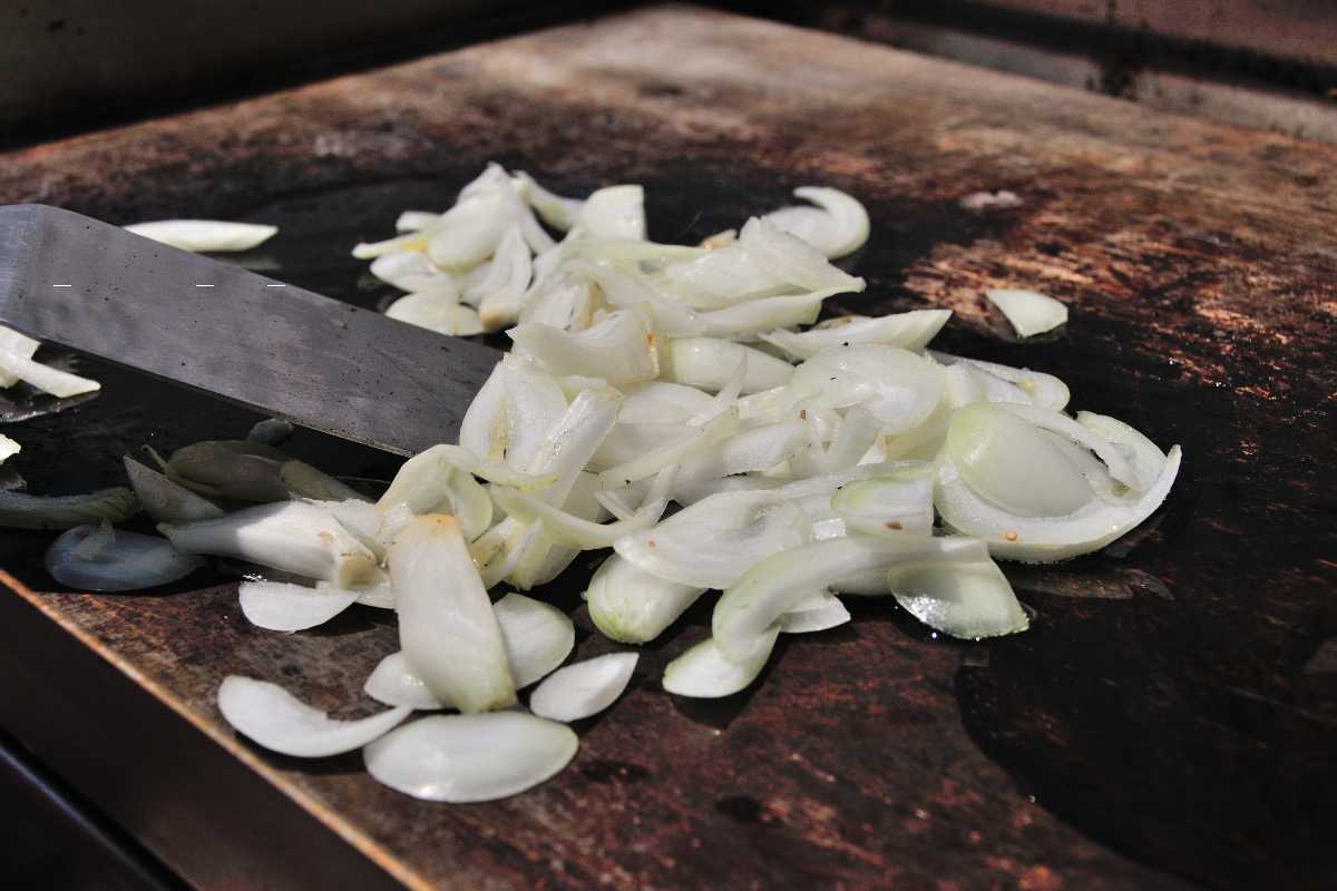 sliced onions on a hot griddle.