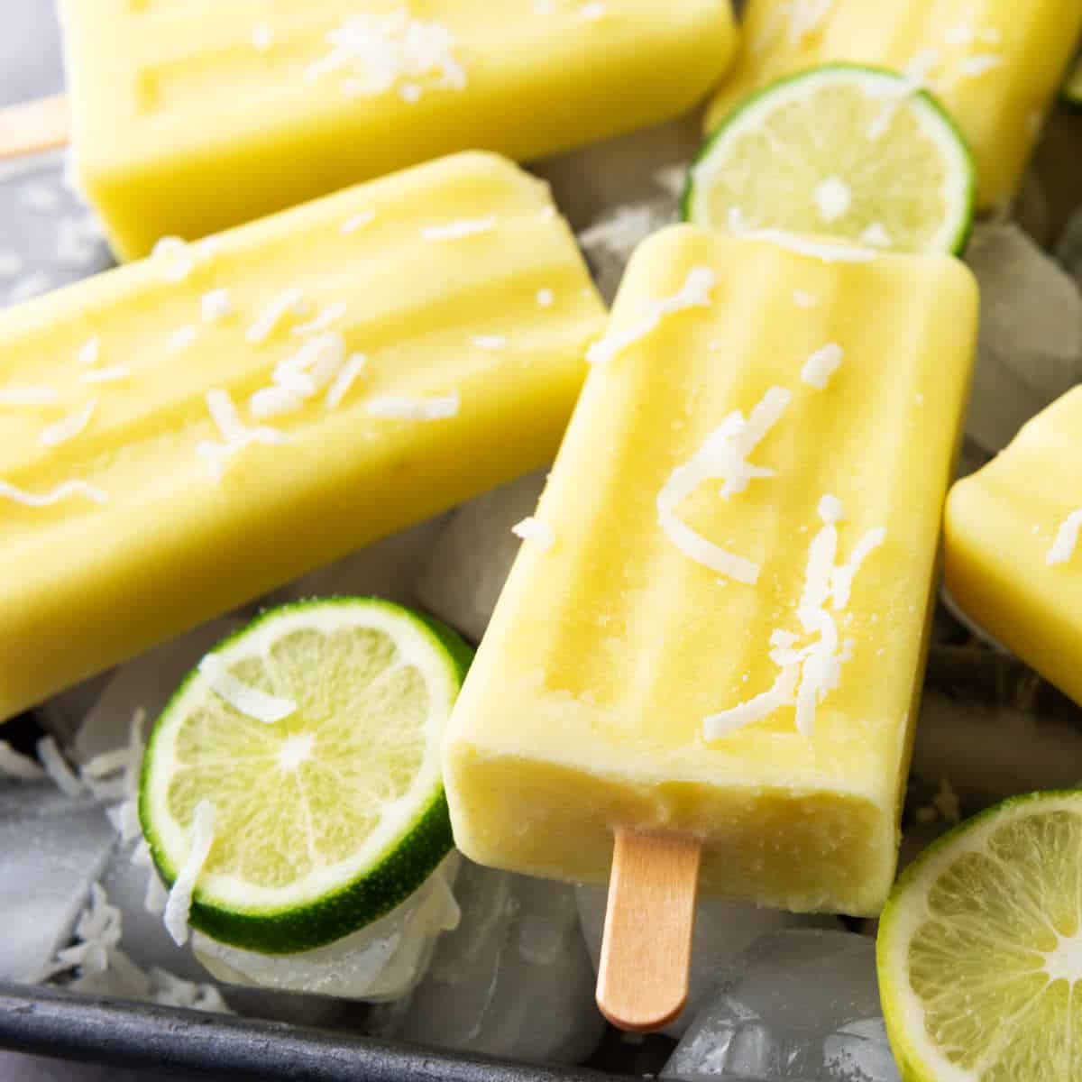baking sheet covered with ice cubes and pineapple popsicles.