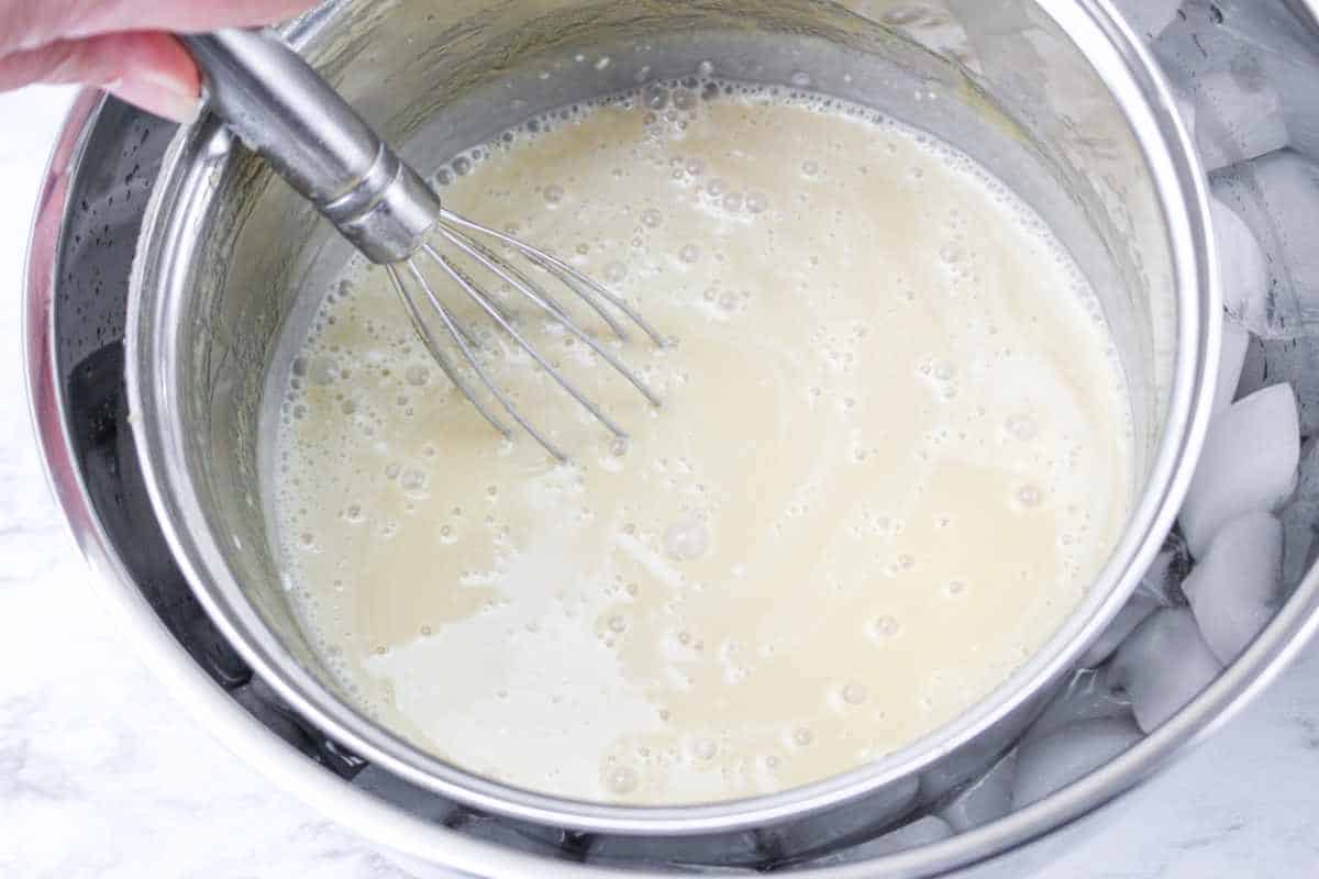 whisking over pan of custard over ice to cool custard down.