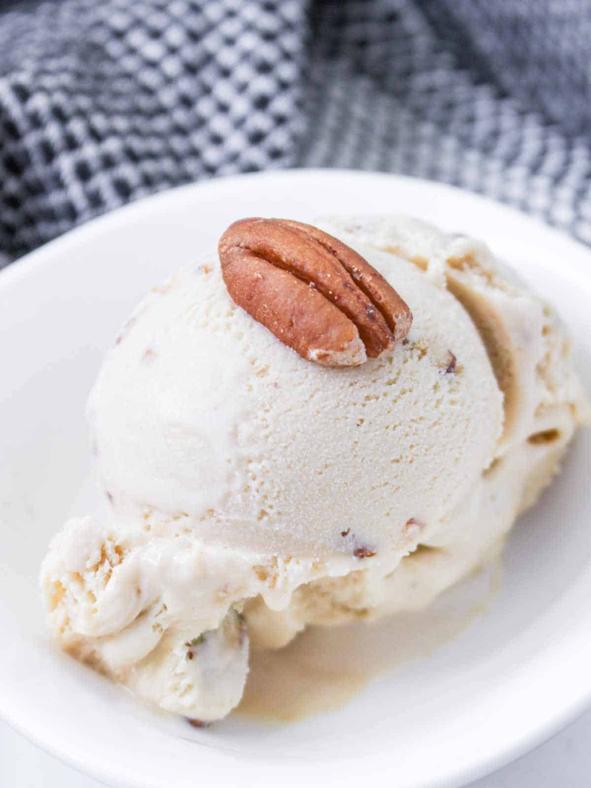 scoop of praline and cream ice cream in a white bowl.