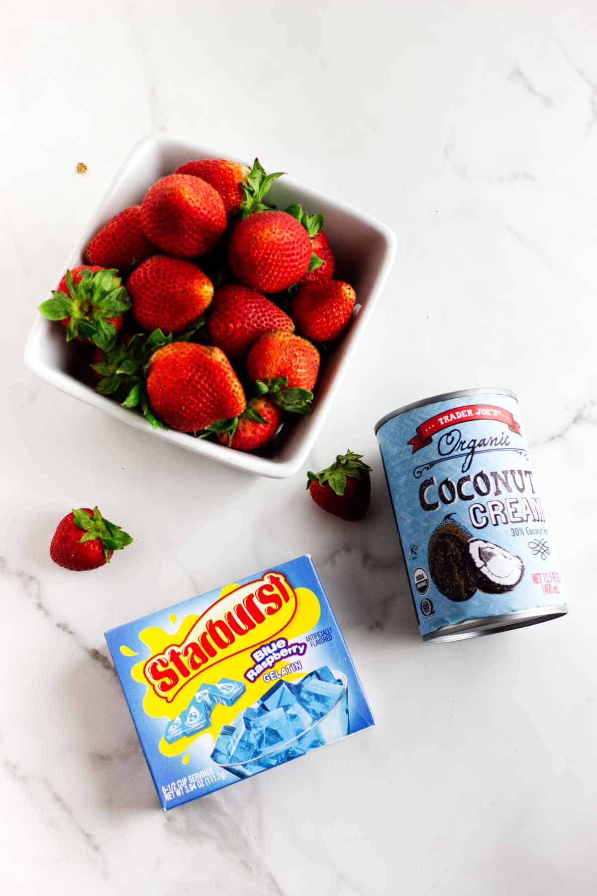 basket of fresh strawberries, can of coconut cream, and a box of blue raspberry jello.