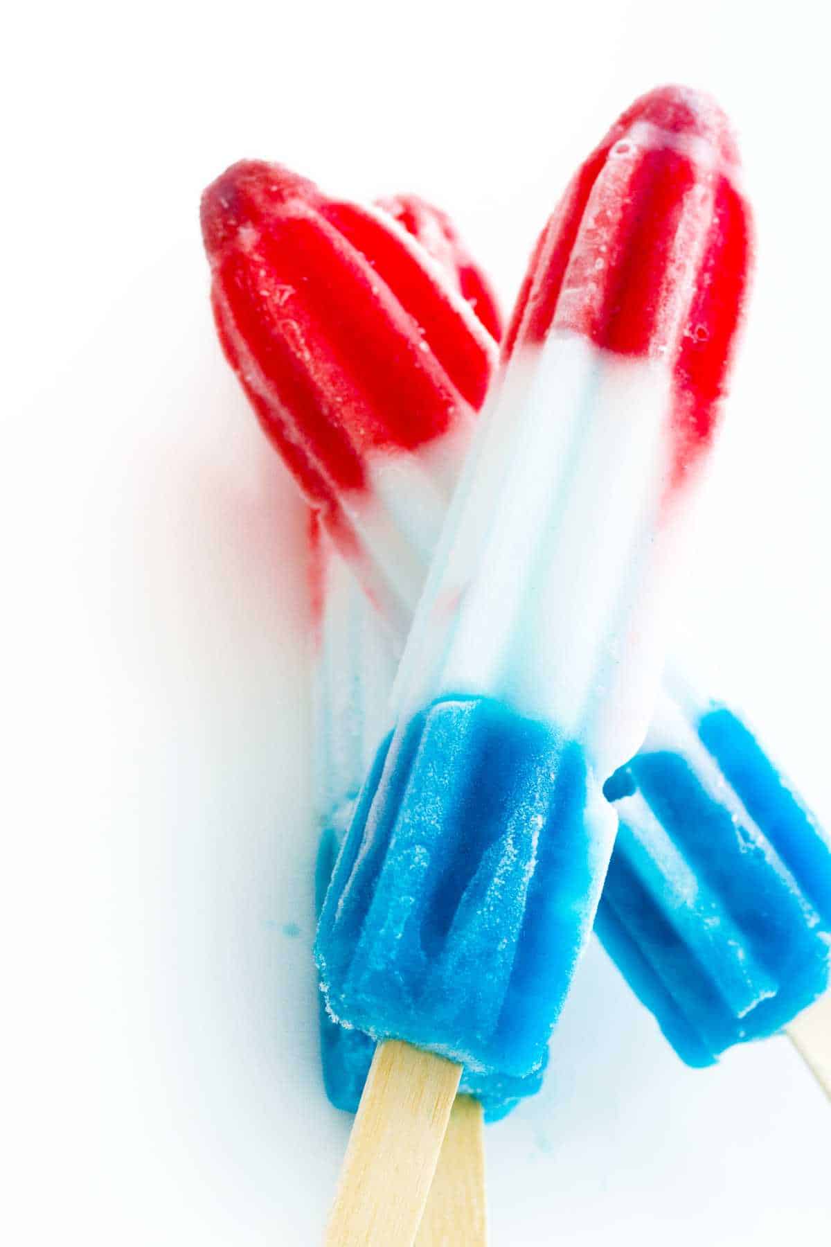 red white and blue popsicles on a tray of ice cubes.
