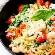 pasta tossed with cream sauce, shrimp, tomatoes, and spinach.