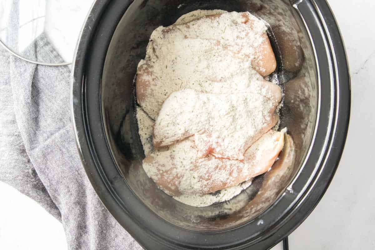 ranch dressing packet sprinkled on top of contents of a crockpot.