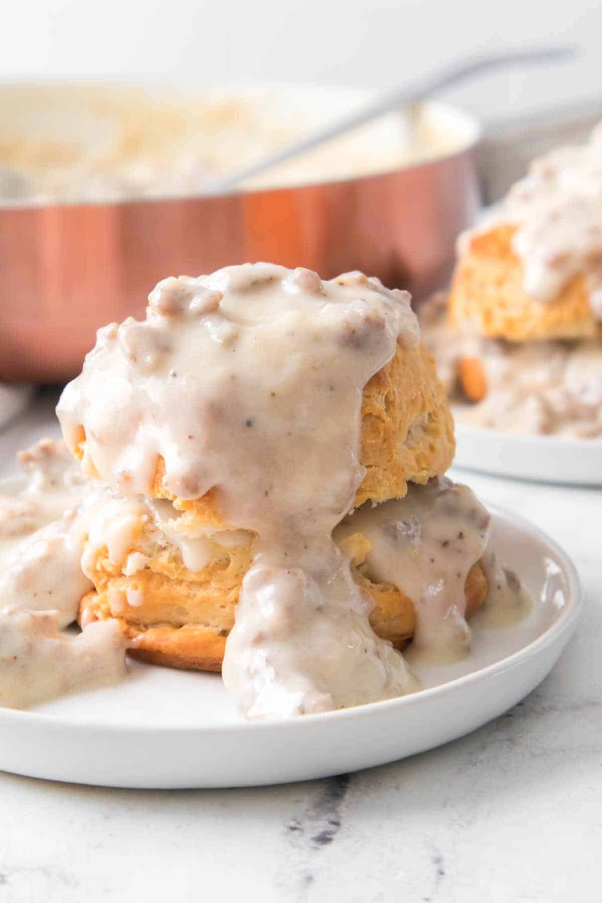 white pepper gravy covered biscuit on a plate.