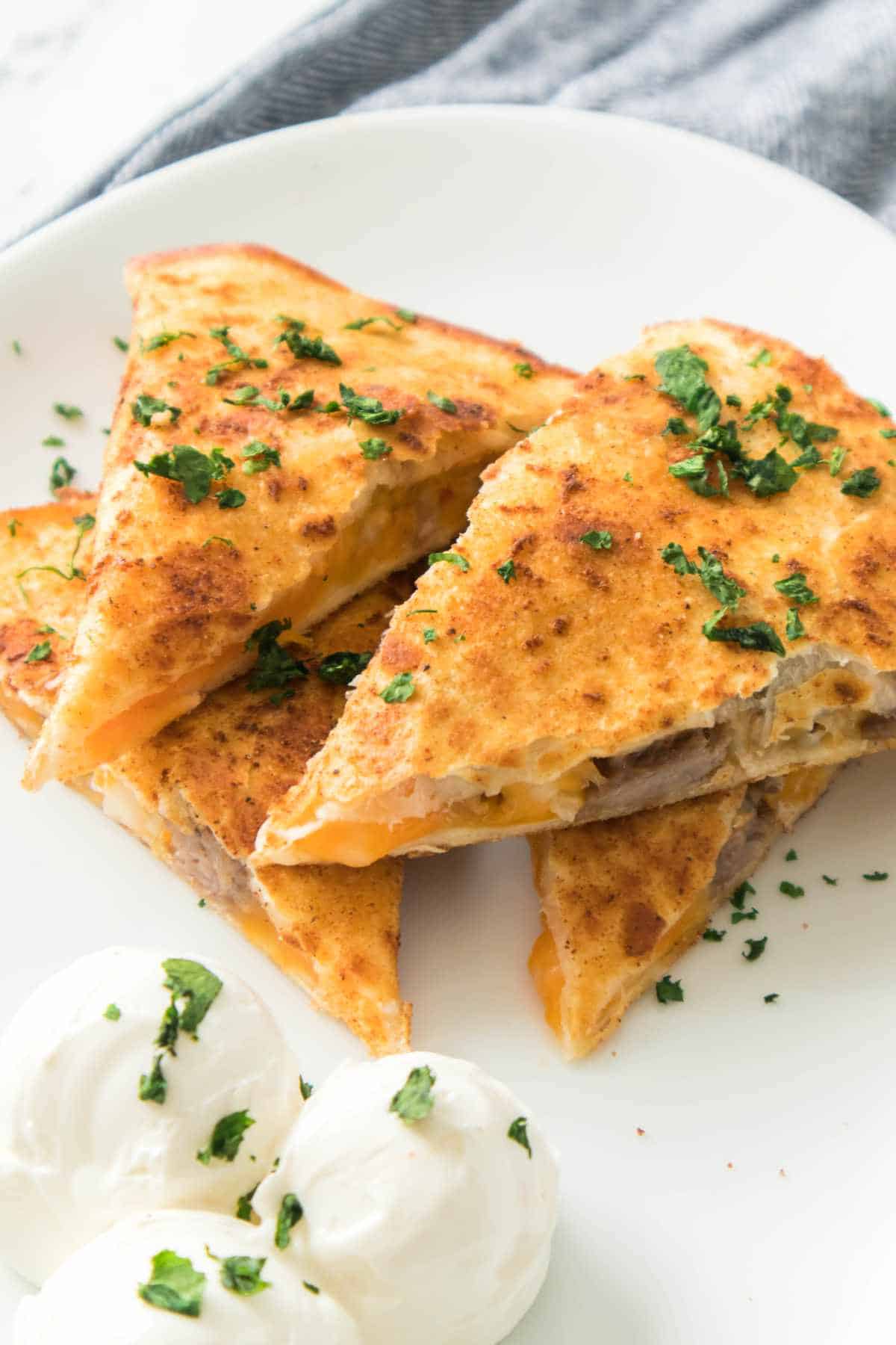 steak quesadilla triangles on a white serving plate.