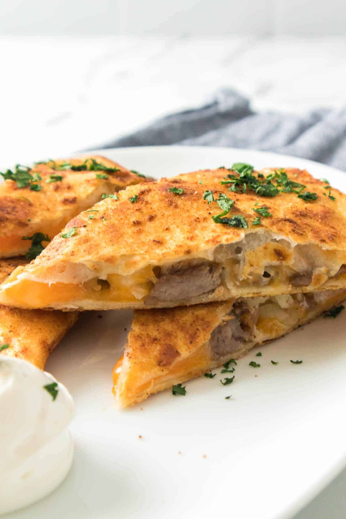 steak quesadilla cut into three triangles and served with sour cream or Mexican white sauce.