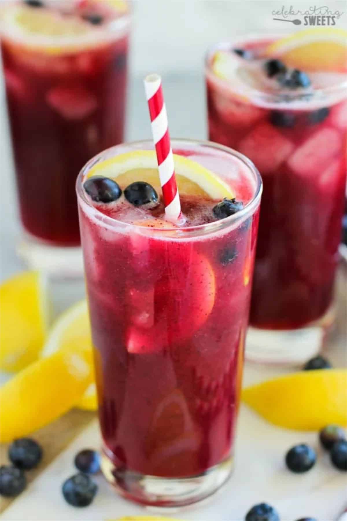berry ade with blueberries and a straw.