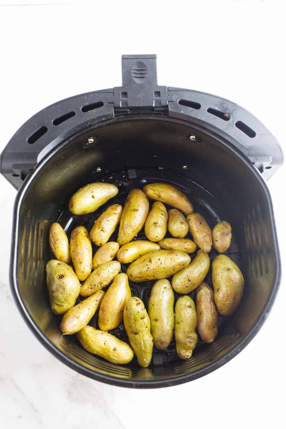 cooked fingerlings in an air frying basket.