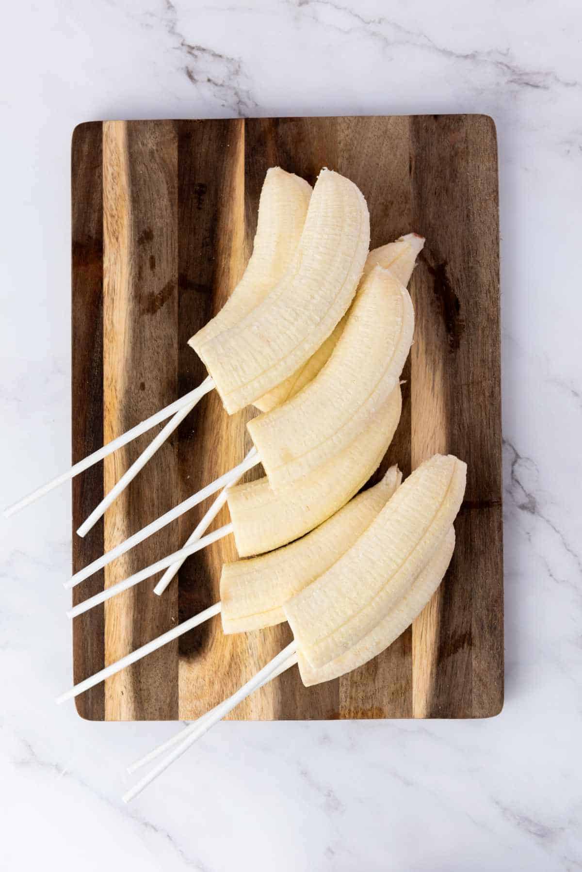 cake pop sticks inserted into one even of each banana half.
