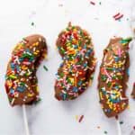 chocolate dipped bananas with colorful sprinkles.