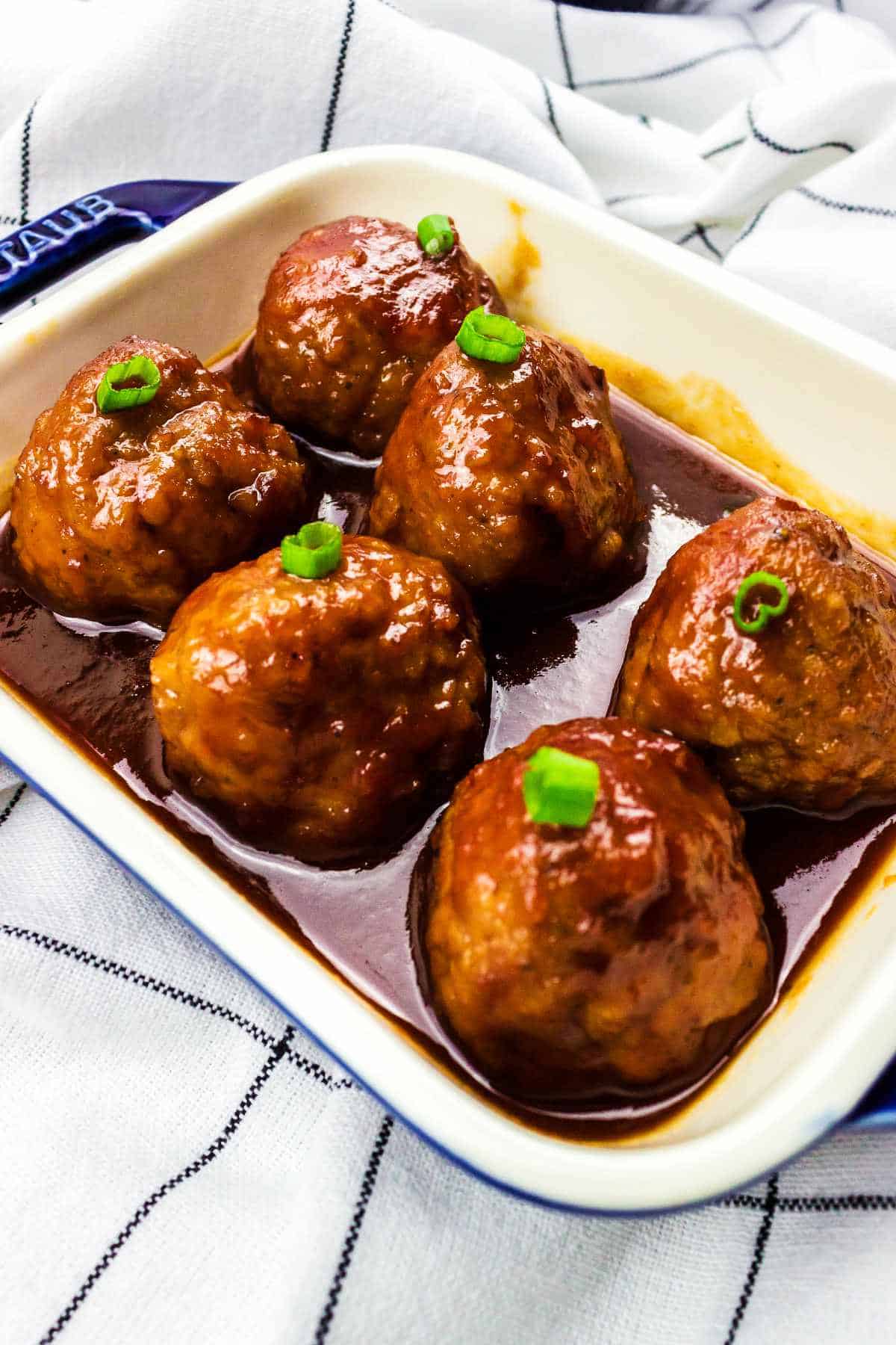 barbeque meatballs with grape jelly in a casserole dish.