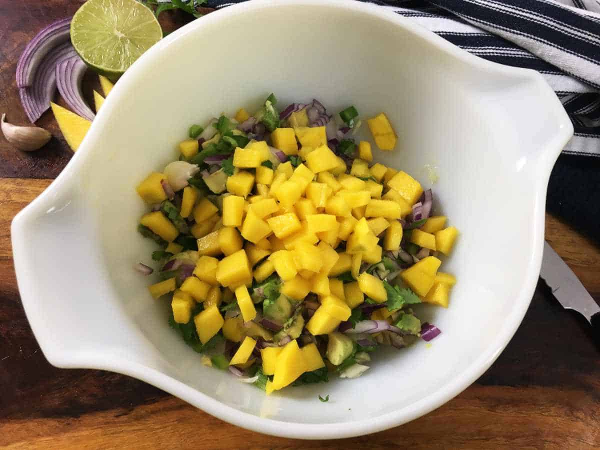 bowl of chopped mango, green bell pepper, red onion, and avocado.