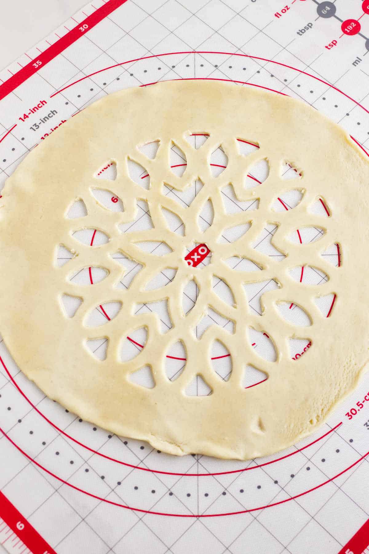 stencil cut lattice pie crust on a pastry mat.
