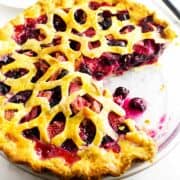 baked blueberry strawberry fruit pie with a slice removed.