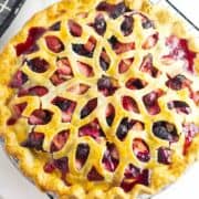 cooling blueberry strawberry pie on a rack.