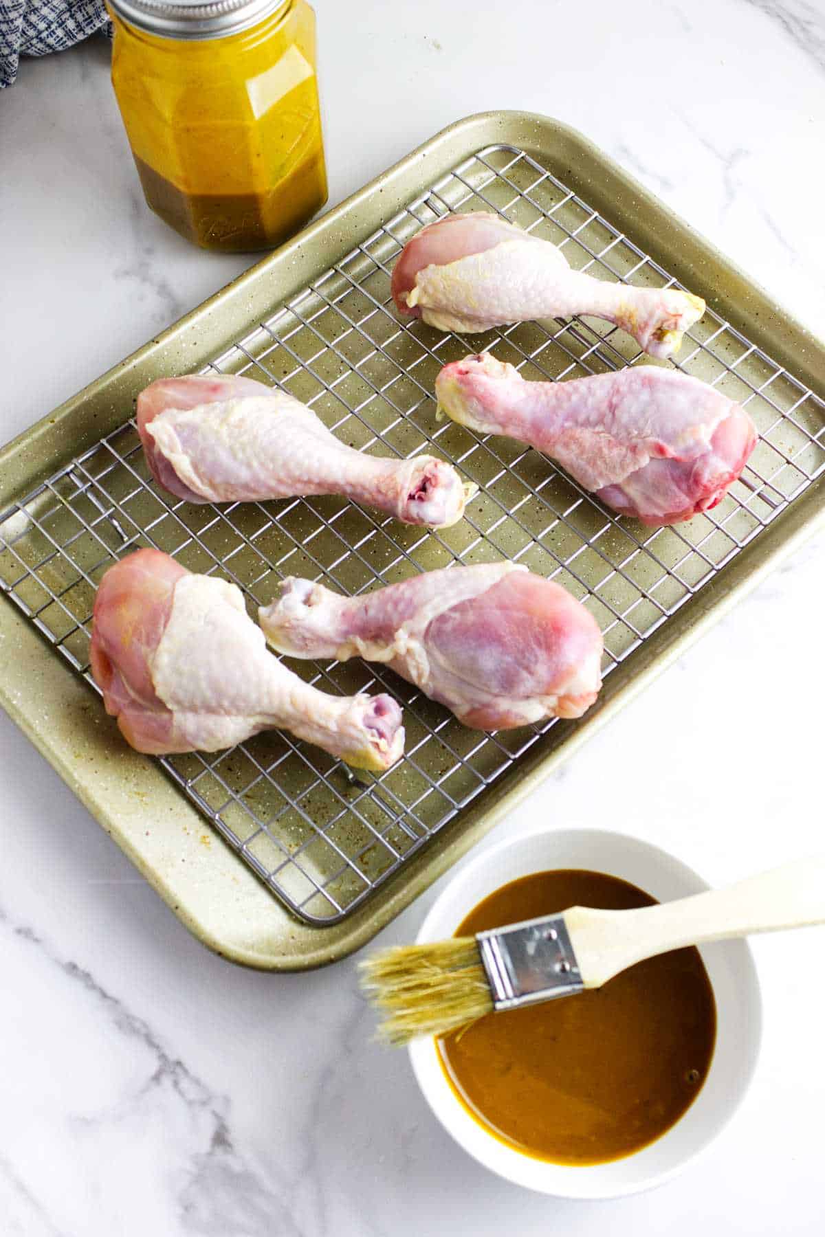 chicken legs on a tray with Honey Gold barbecue sauce nearby.