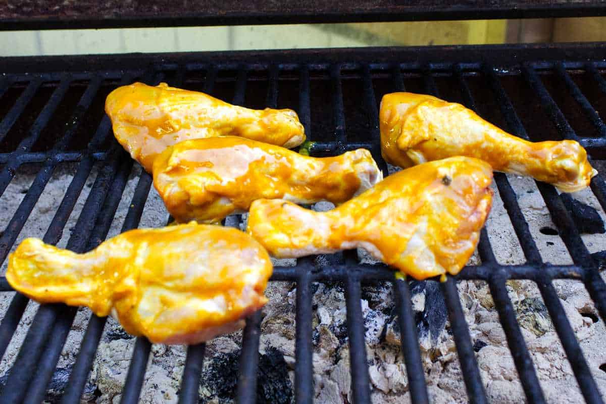 barbecue coated chicken legs on a grill.