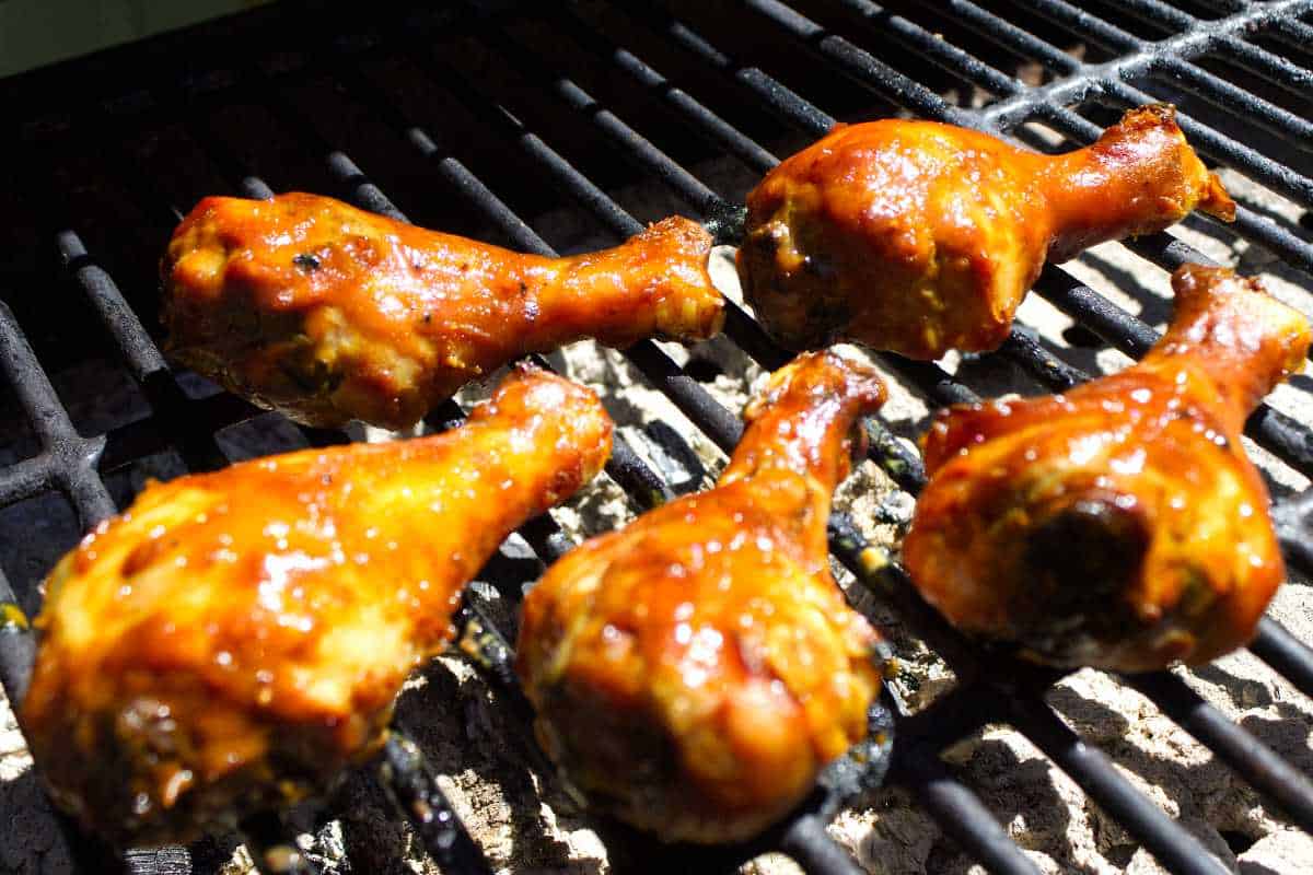 barbecue coated chicken legs on a grill.