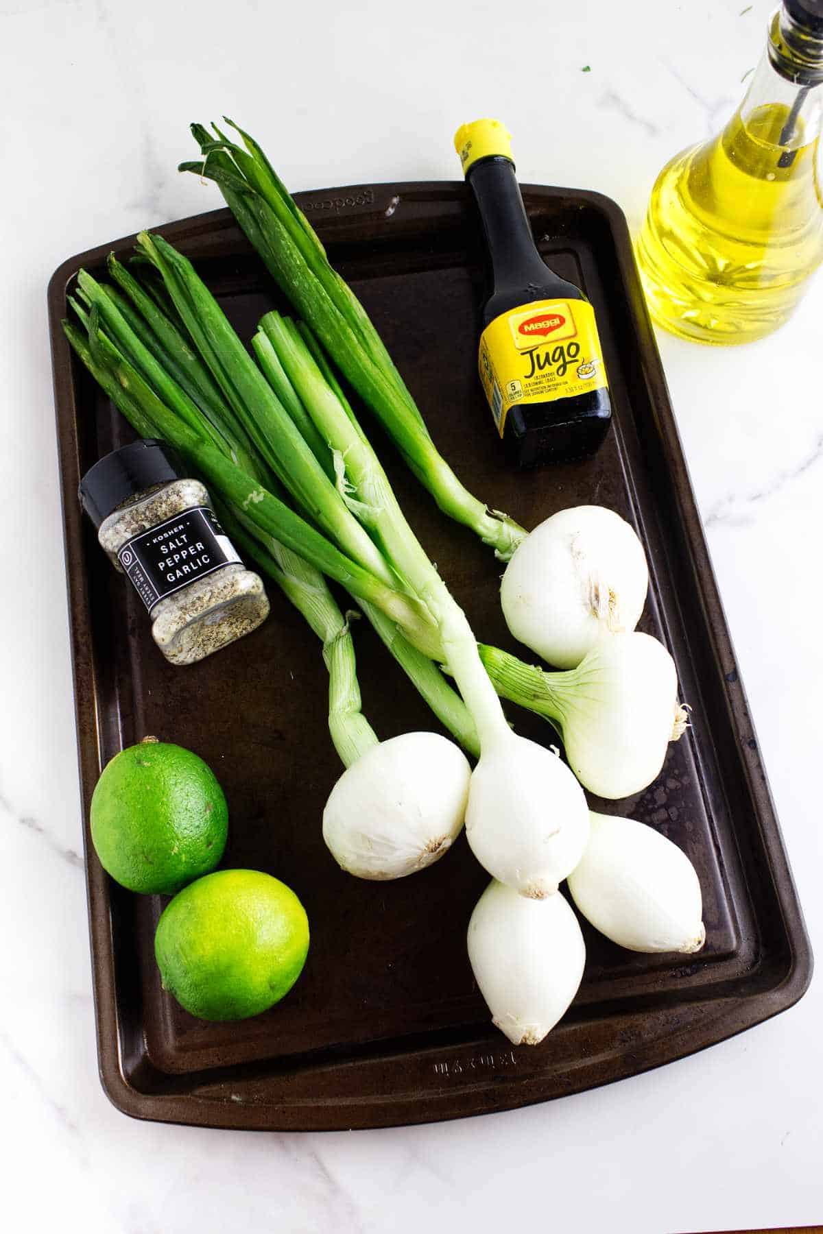 large bulb scallions, Jugo seasoning, olive oil, and seasoning on a sheet pan.