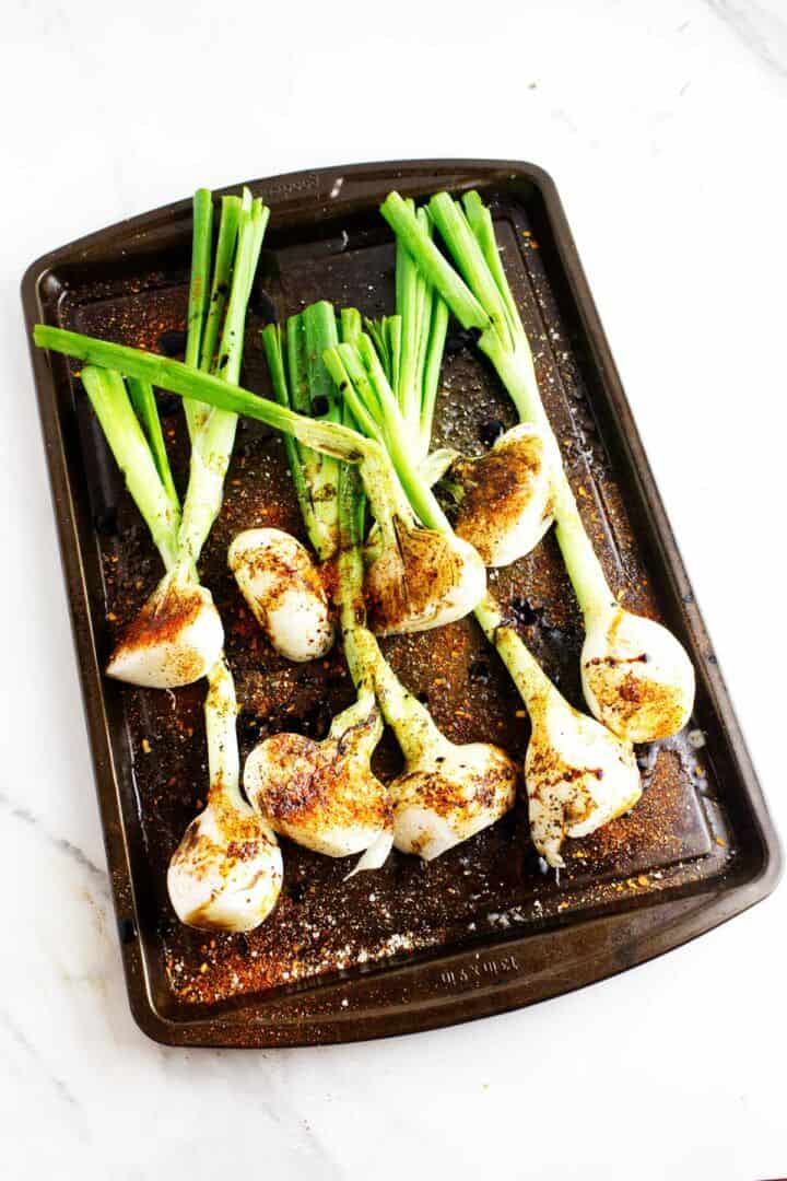 Cebollitas ready to roast on a sheet pan.