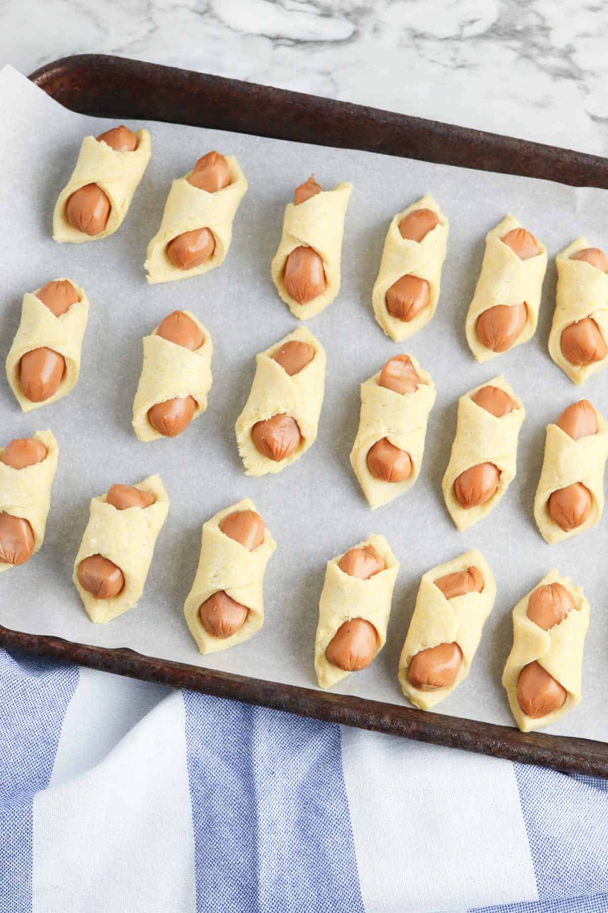 air fryer tray with pigs in a blanket on the tray.