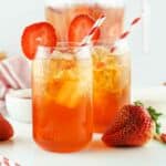 glass and pitcher of strawberry Arnold Palmer iced tea.