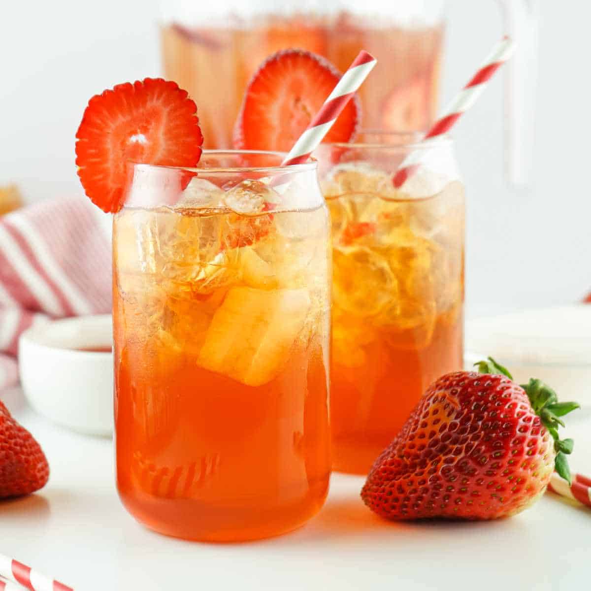 glass and pitcher of strawberry Arnold Palmer iced tea.
