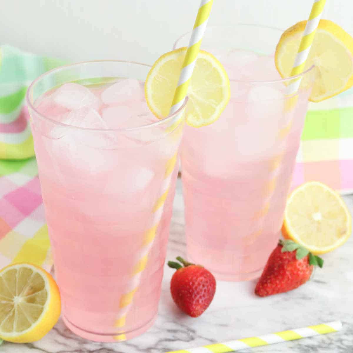 Lemon slices garnishing the tops of glasses of Strawberry Lemonade Spritzers.