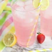 Lemon slices garnishing the tops of glasses of Strawberry Lemonade Spritzers.
