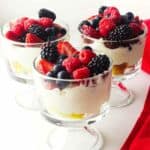 three individual summer berry trifles in clear glass mini trifle bowls.