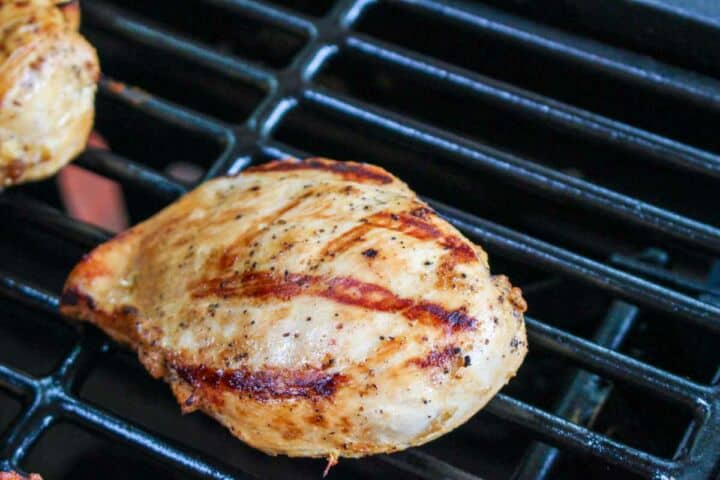 skinless, boneless chicken breasts grilling on a grill.