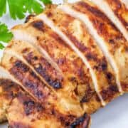 sliced, grilled chicken breasts on a plate.