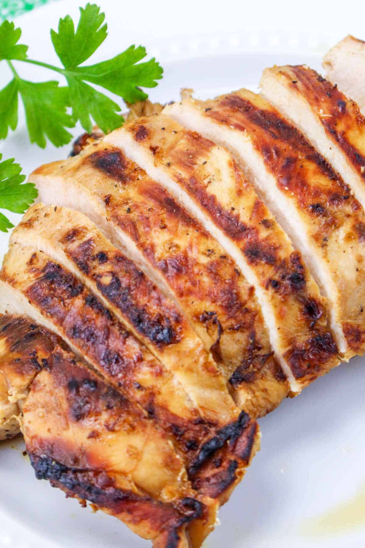 sliced, grilled chicken breasts on a plate.