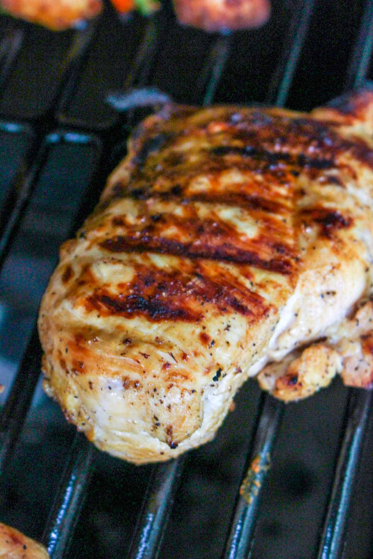 skinless, boneless chicken breasts grilling on a grill.