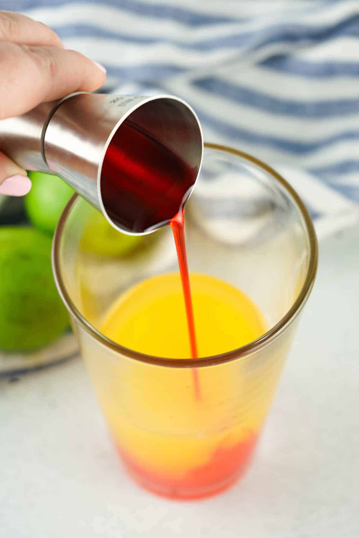 grenadine syrup added to a tumbler of orange juice.