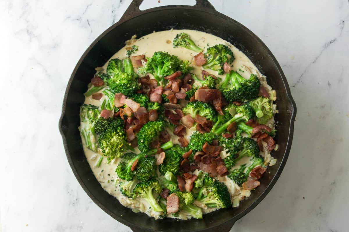 bacon added to skillet with broccoli and sauce.