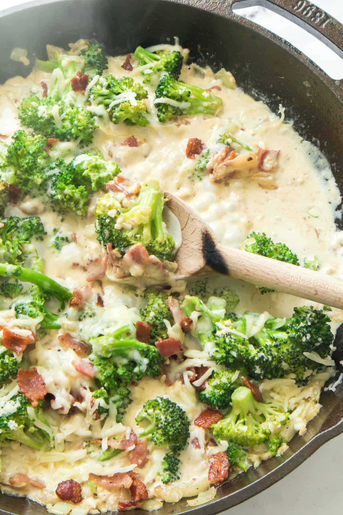 creamy broccoli and bacon alfredo in a cast iron skillet.