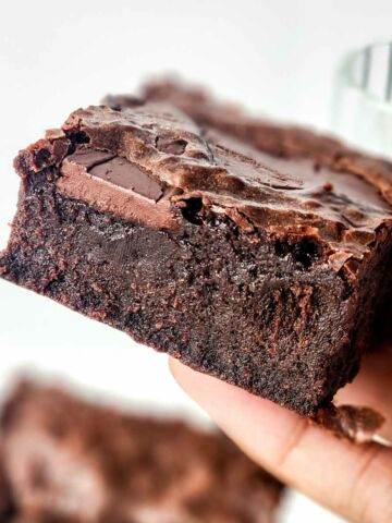 moist and fudgy condensed milk brownie held in a hand.