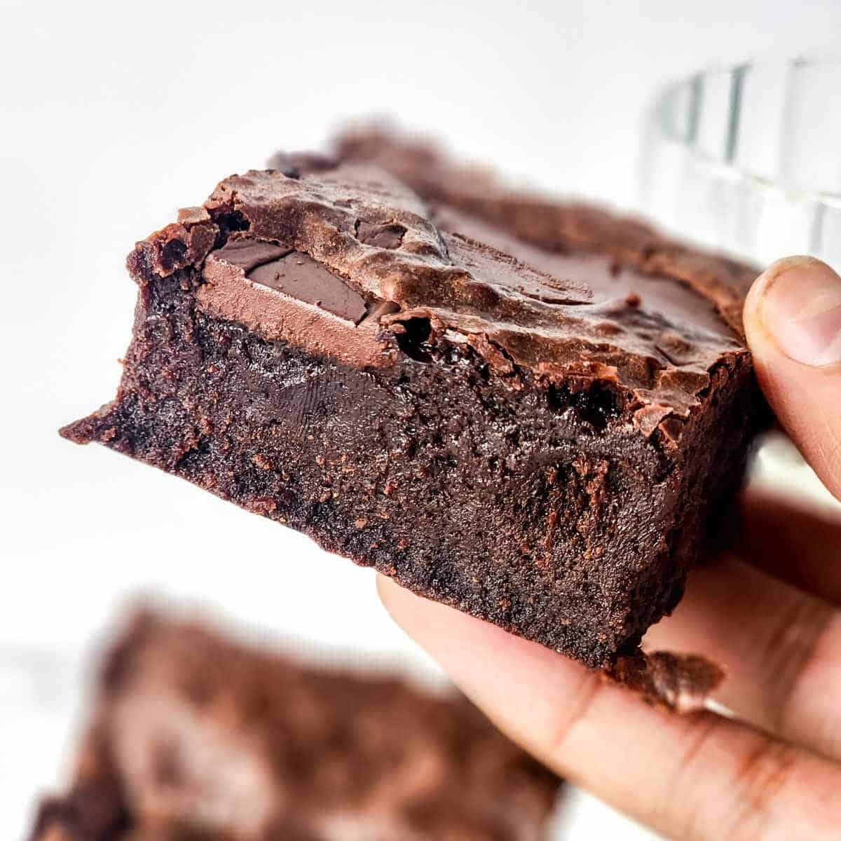 moist and fudgy condensed milk brownie held in a hand.