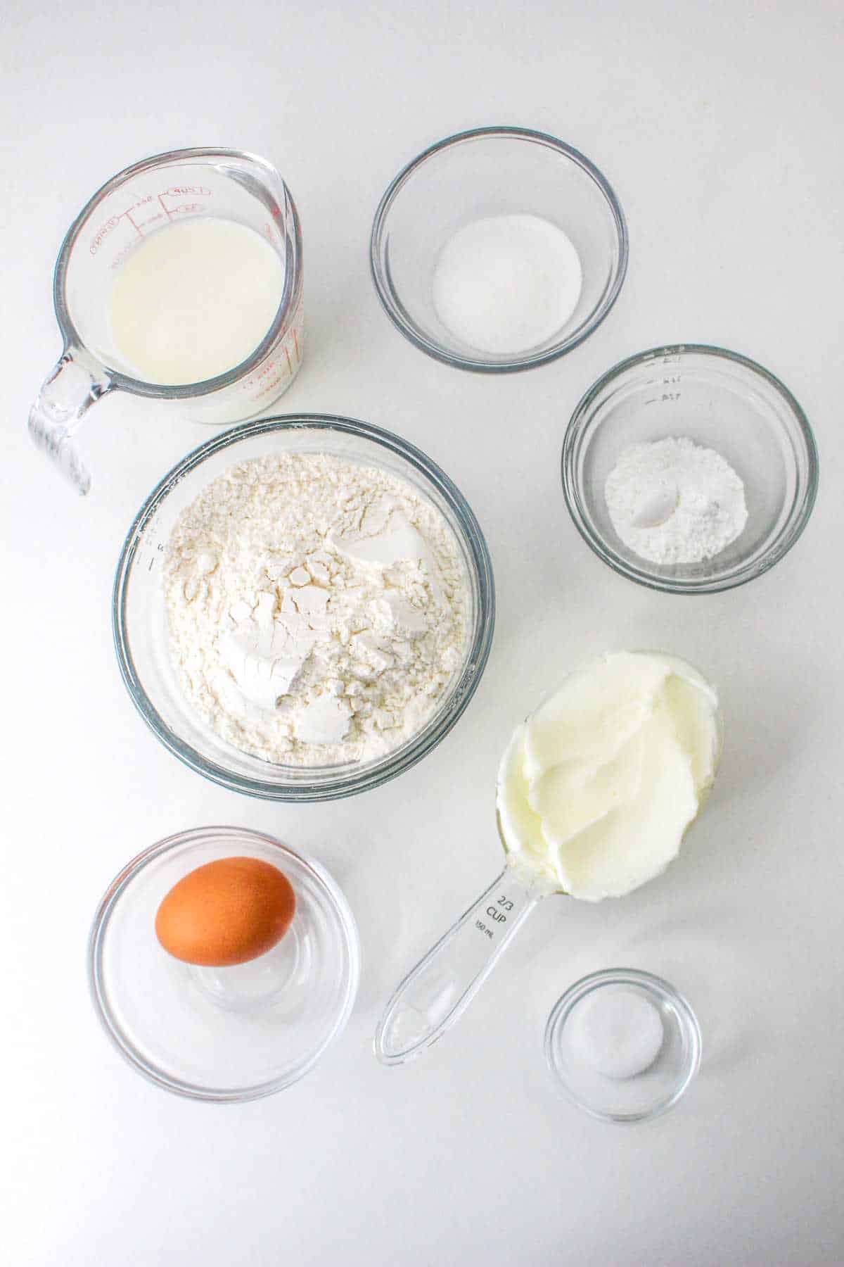bowls of flour, shortening, egg, salt, buttermilk, and baking powder.