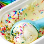 scooping funfetti ice cream from storage container.