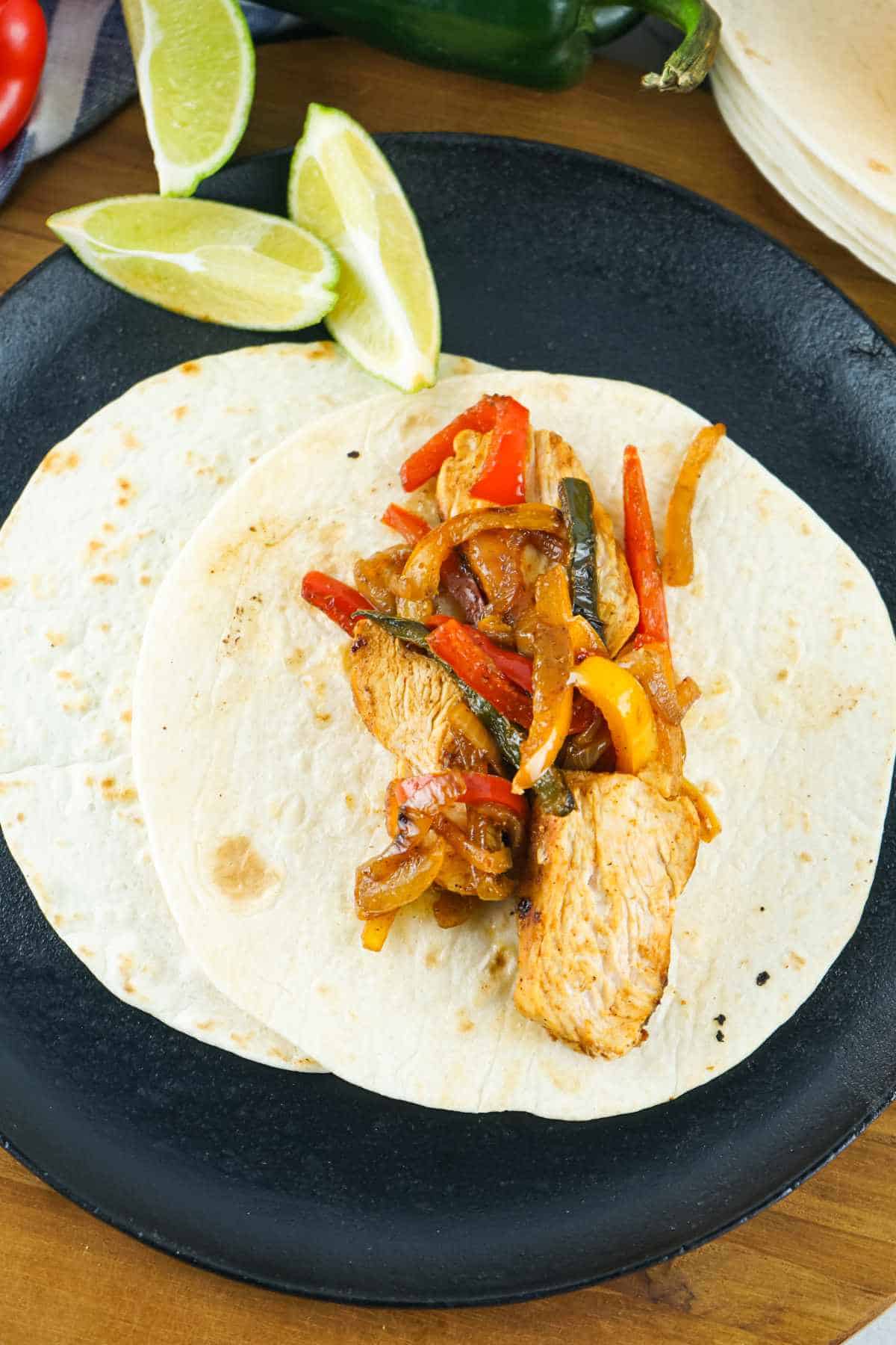 flour tortillas loaded with cooked vegetables and meat.
