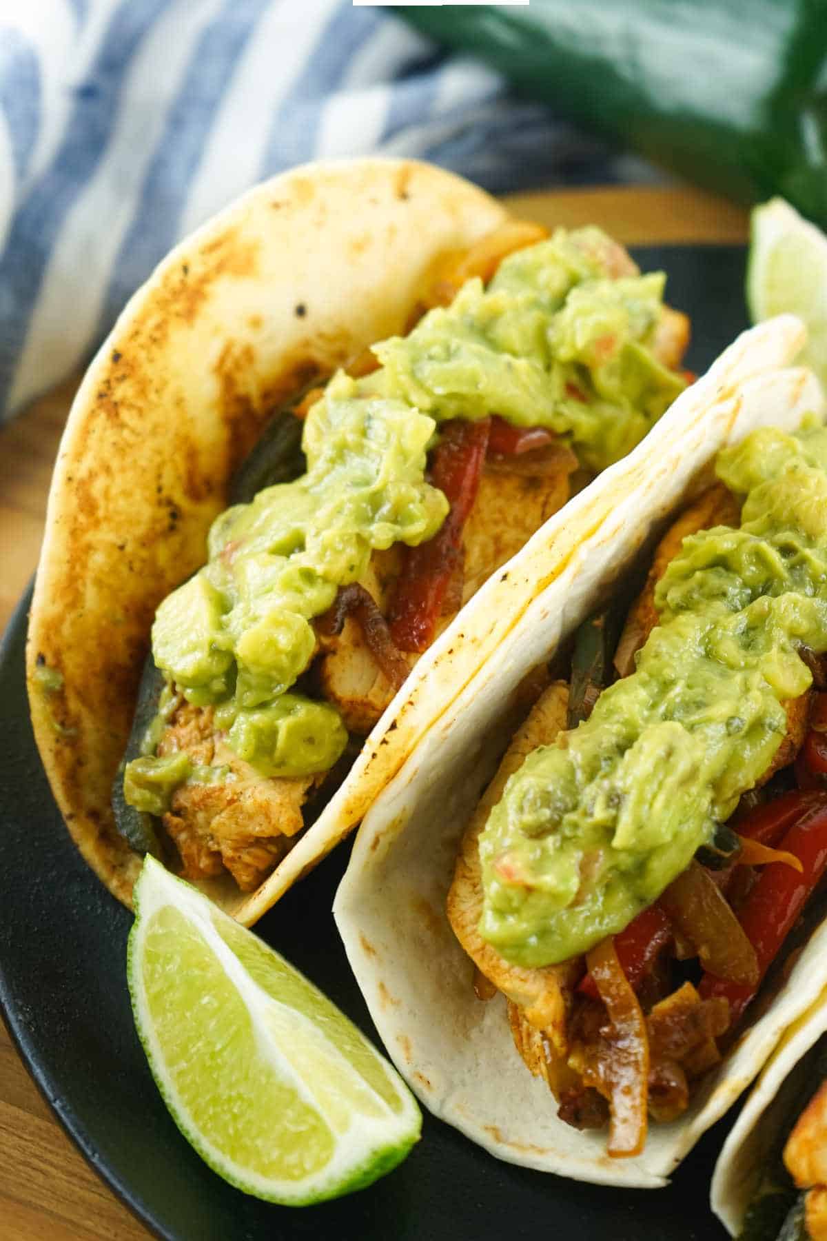 guacamole loaded tortilla wraps with meat and veggies.