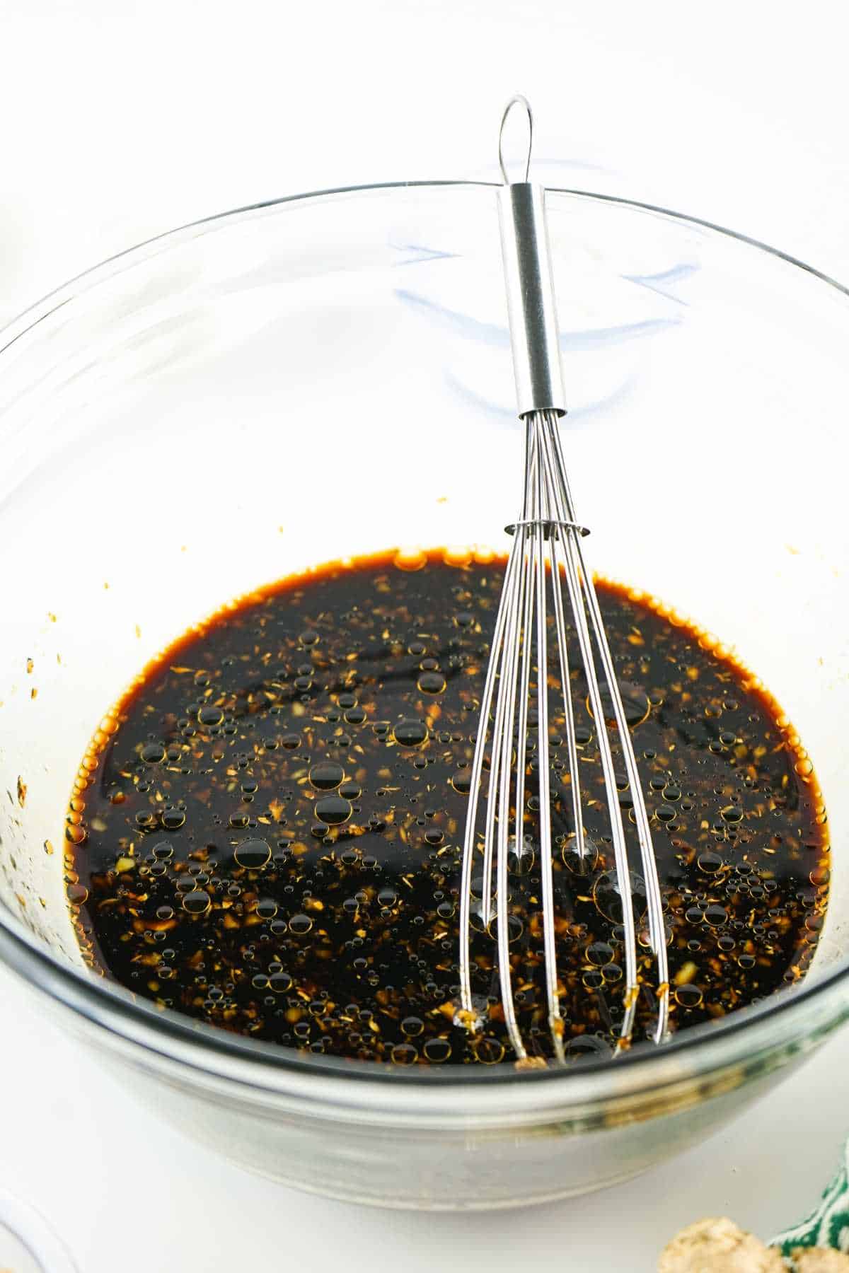 bowl of dark sauce with a whisk.