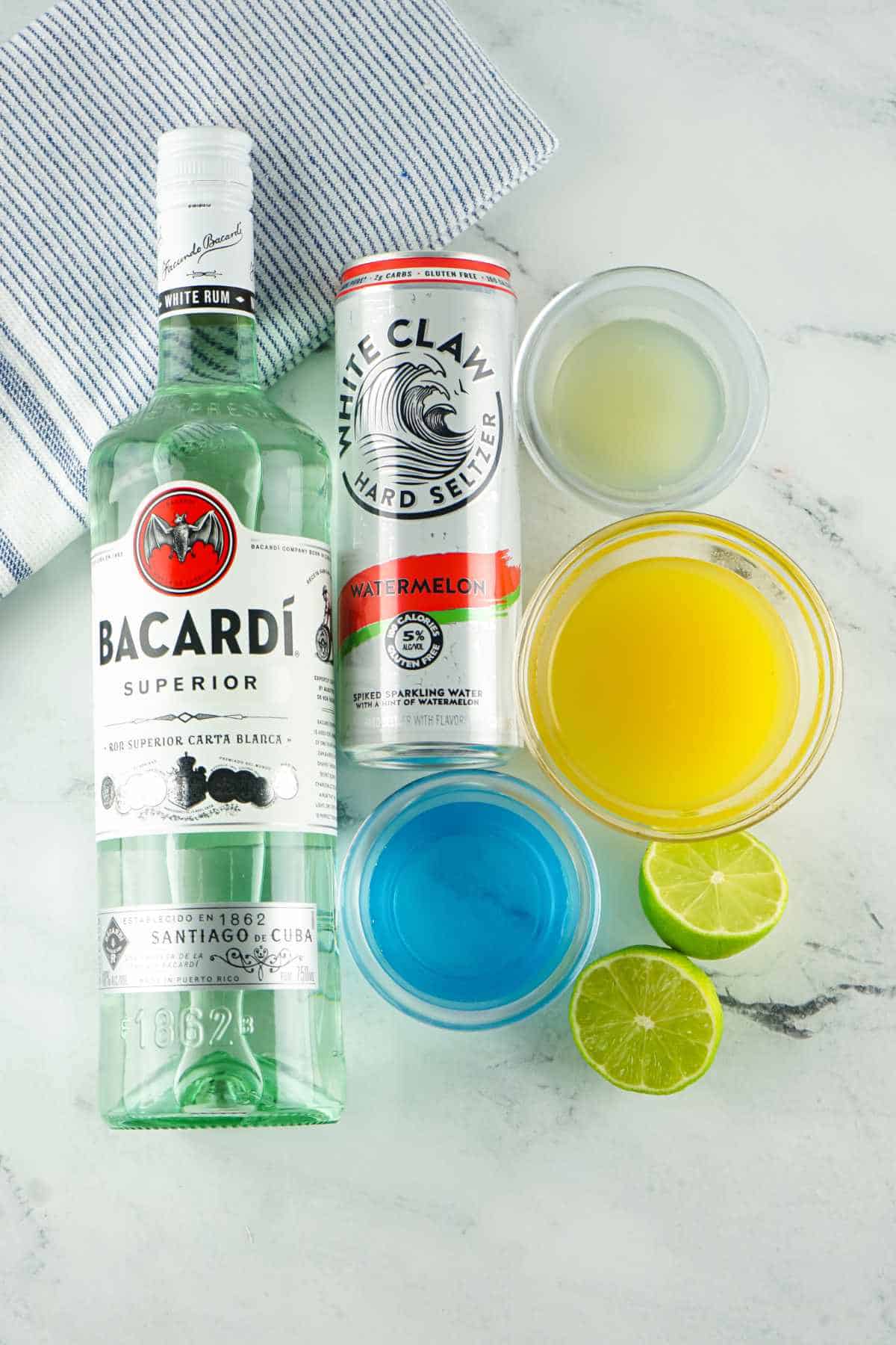 ingredients for making tipsy mermaid drinks: Bacardi Rum, White Claw, pineapple juice, blue curacao, and lime juice.