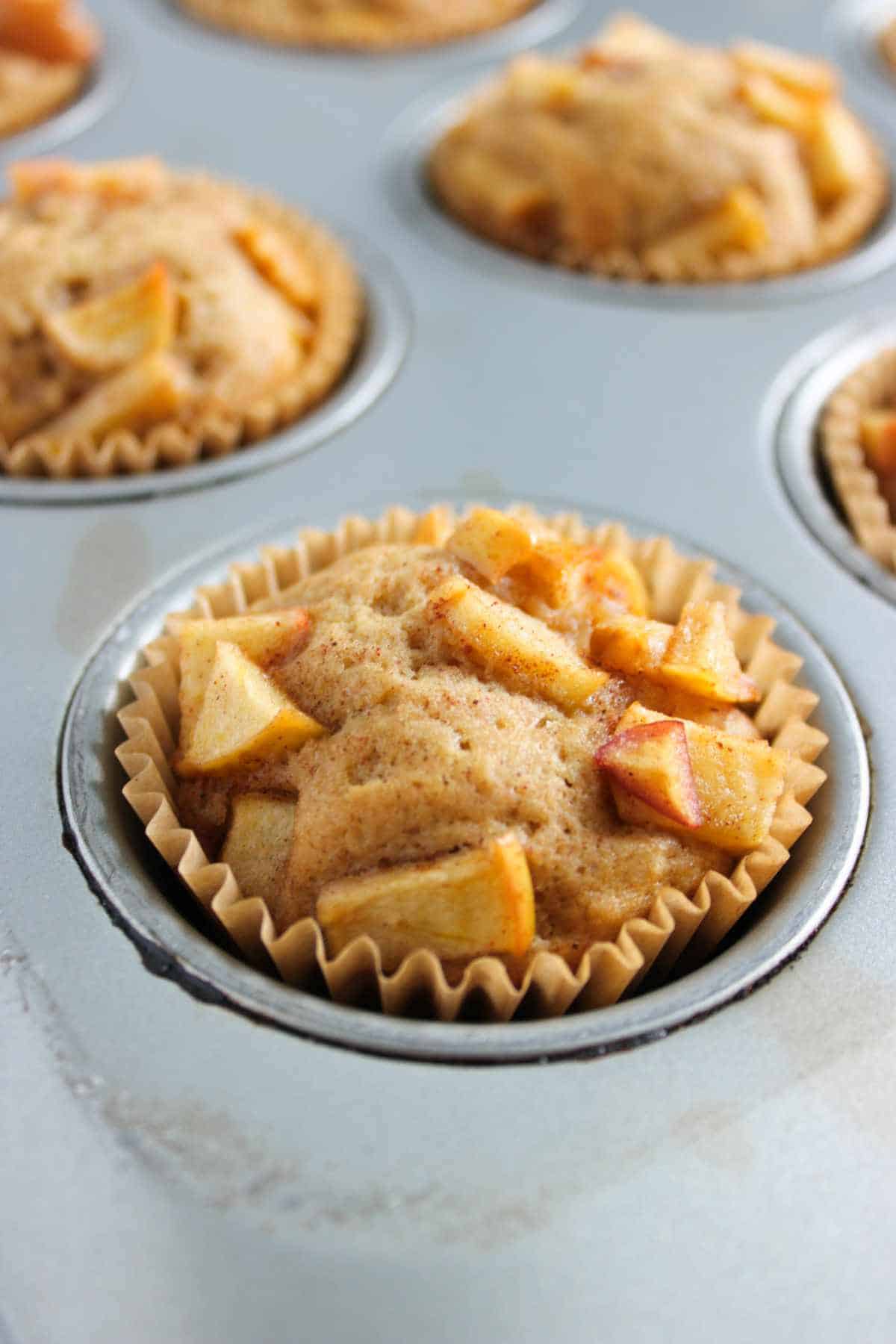 baked cupcakes with apple filling on top.