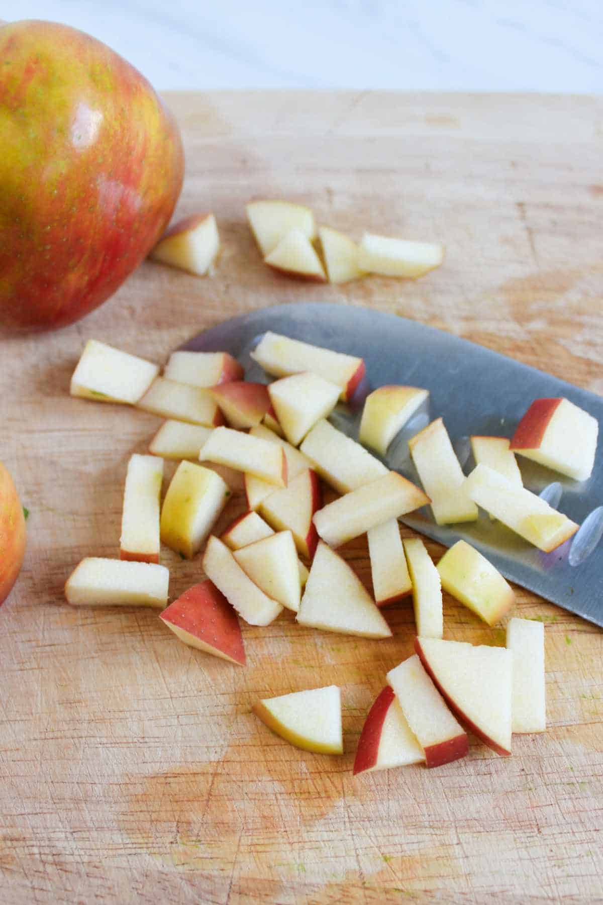 cutting board with apple being diced.