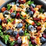 blueberry kale crunch salad in a bowl with feta cheese crumbled on top.