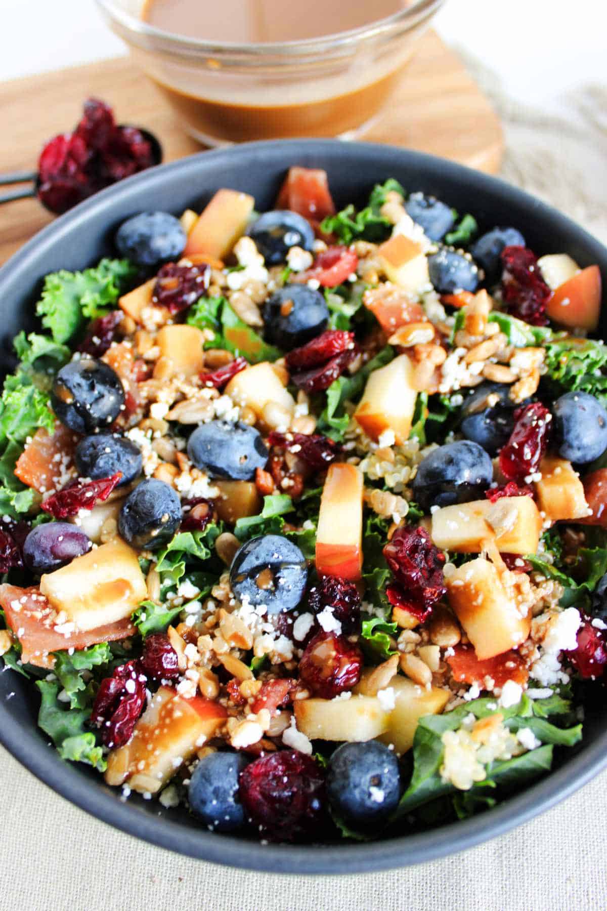 blueberry kale crunch salad in a bowl with feta cheese crumbled on top.